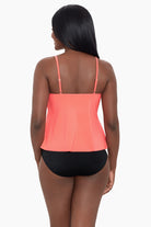 Woman turned away wearing a coral-colored ruffle tankini top