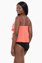 Woman turned left wearing a coral-colored ruffle tankini top