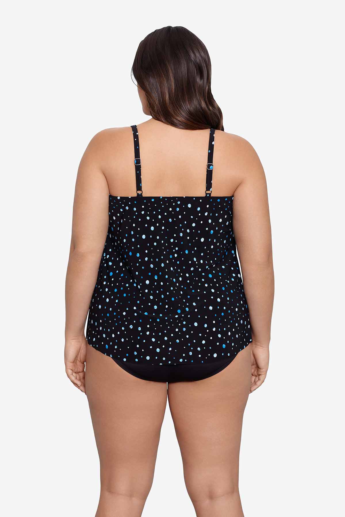 Woman faced away wearing a black and blue polka dotted tankini top