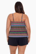 Woman faced away wearing a rainbow stripe and dash pattern swim romper