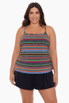 Woman wearing a rainbow stripe and dash pattern swim romper