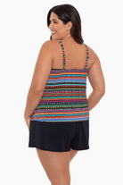 Woman turned left wearing a rainbow stripe and dash pattern swim romper