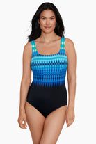 Woman wearing a black and blue tie-dye-esque printed one-piece swimsuit