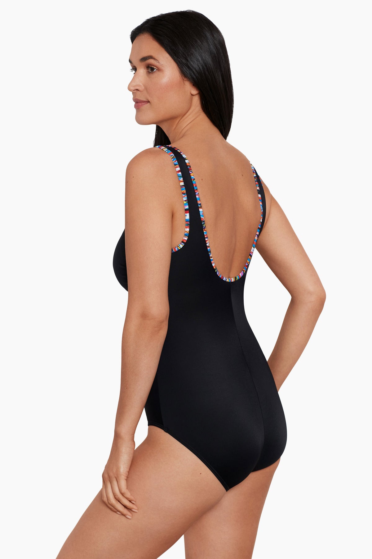 Woman turned left wearing a black one-piece swimsuit with rainbow piping on the edges