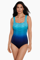Woman wearing a blue ombre zig zag pattern one-piece swimsuit