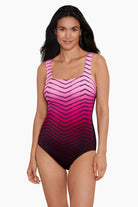Woman wearing a pink ombre zig zag pattern one-piece swimsuit