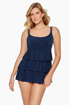 Woman wearing a navy-blue swim dress with ruffled tiers