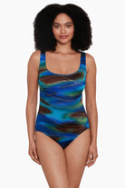 Woman wearing a tie dye print with a gold streaky overlay one-piece swimsuit