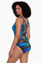 Woman turned left wearing a tie dye print with a gold streaky overlay one-piece swimsuit