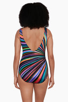 Woman turned away wearing a rainbow radial pattern one-piece swimsuit