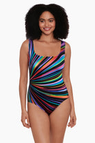 Woman wearing a rainbow radial pattern one-piece swimsuit