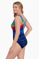 Woman faced left wearing a rainbow ombre with a geometric overlay print one-piece swimsuit