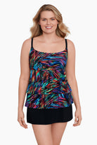 Woman wearing a rainbow light burst pattern ruffle one-piece skirtini swimsuit