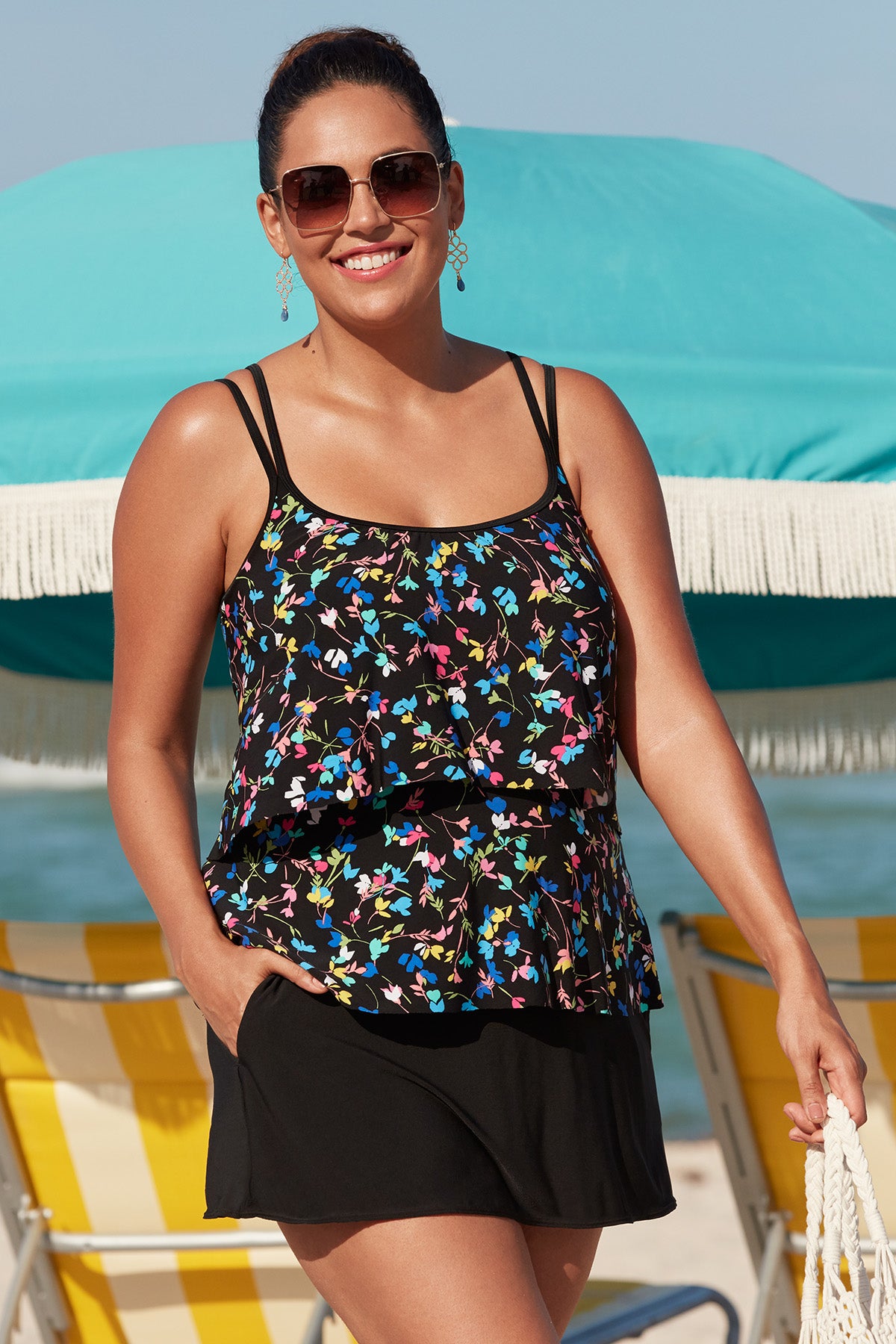 Woman on beach wearing a multicolored tiny floral printed one-piece faux skirtini ruffle swimsuit