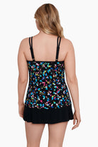Woman faced away wearing a multicolored tiny floral printed one-piece faux skirtini ruffle swimsuit