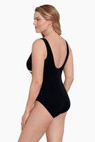 Woman faced left wearing a white and black fan printed one-piece swimsuit
