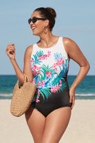 Woman on beach wearing a multicolored floral printed half black and white split one-piece swimsuit