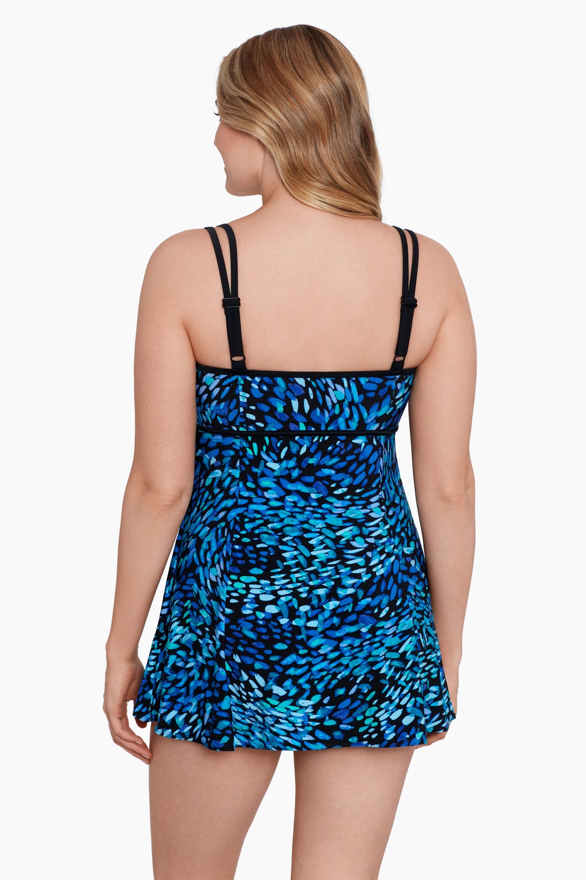 Woman turned away wearing a black and blue petal pattern swim dress