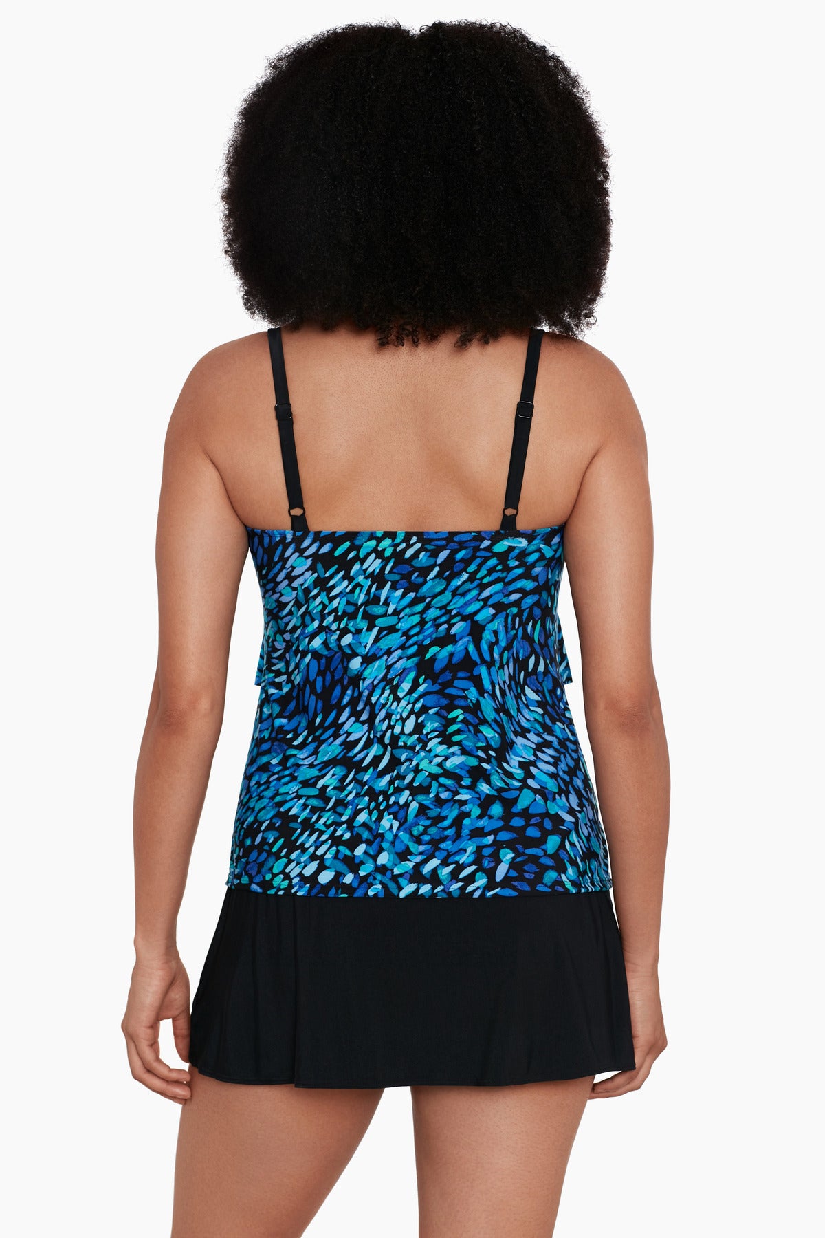 Woman faced away wearing a black and blue petal pattern ruffle faux skirtini one-piece swimsuit