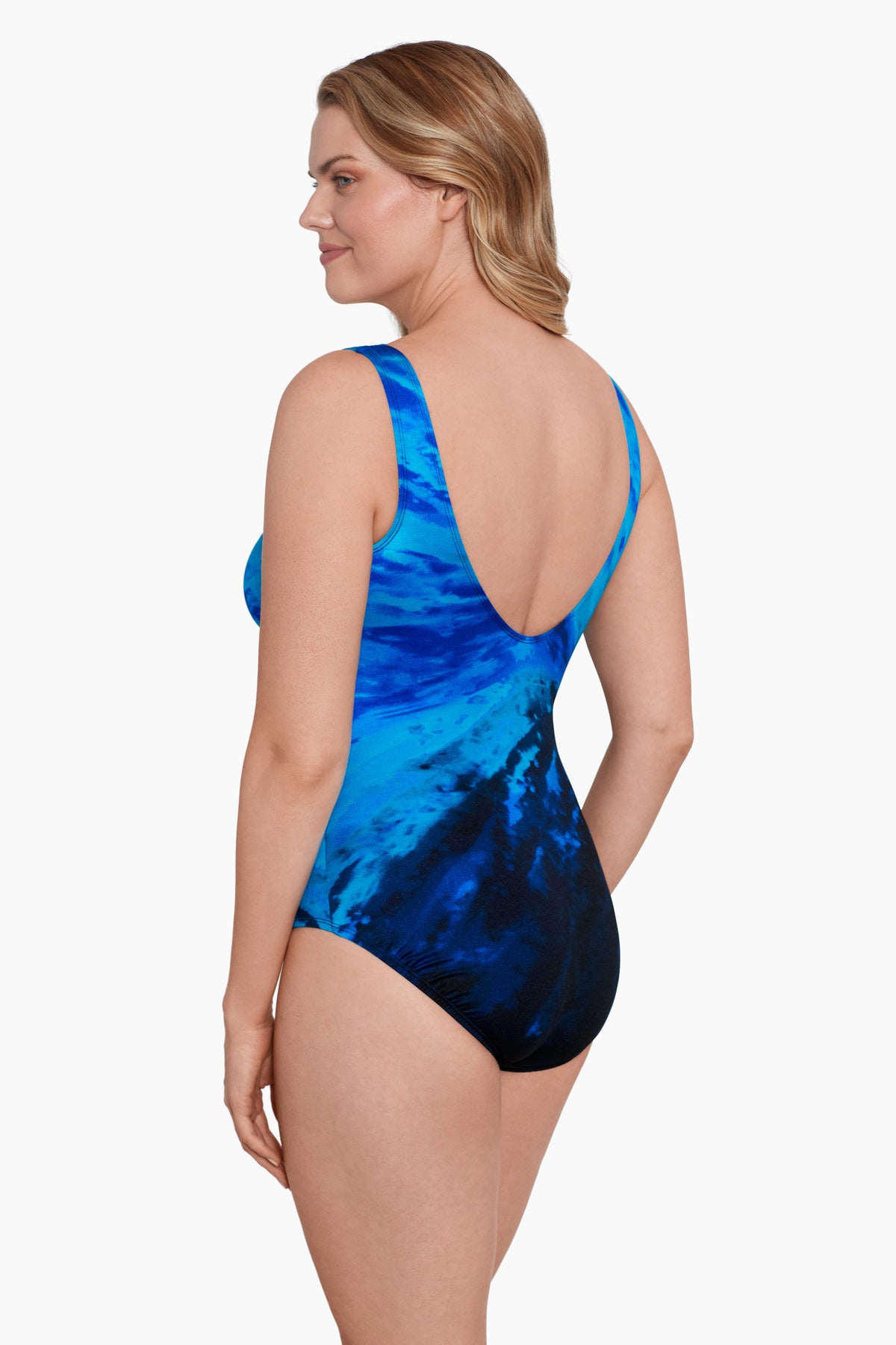 Woman turned left wearing a black and blue tie-dye-esque one-piece swimsuit