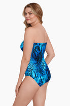Woman turned left wearing a black and blue abstract animal printed one-piece bandeau swimsuit
