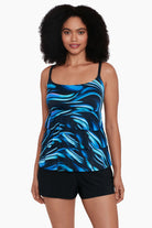 Woman wearing a black and blue oil slick print ruffle tiered one-piece swimsuit shortini