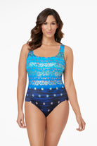 Woman wearing a blue ombre paisley and flower overlay printed one-piece swimsuit